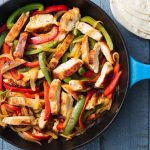 chicken fajitas in a pot with tortillas