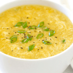 delicious egg drop soup in a bowl with sliced spring onion on top