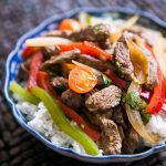 Stir fry pepper steak with rice in a porcelain bowl