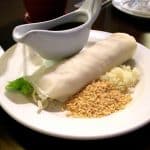 fresh lumpia on plate side with sauce and fried peanuts