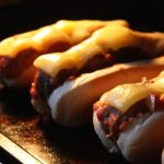 cheesy meatball subs on a wooden tray